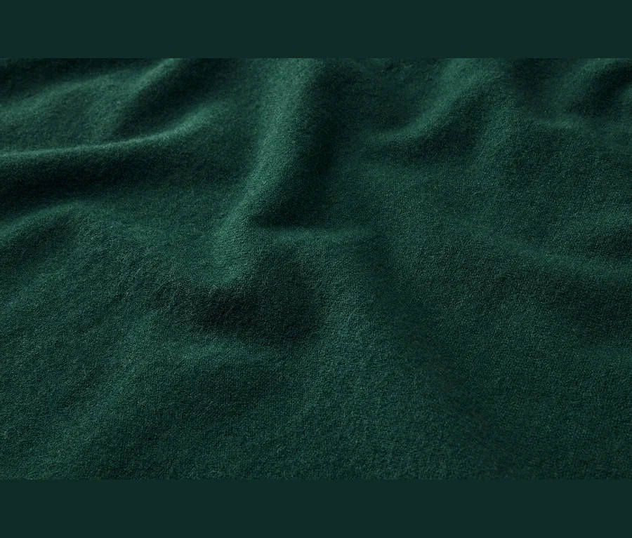 Tissu vert foncé doux avec de légers plis et une texture.