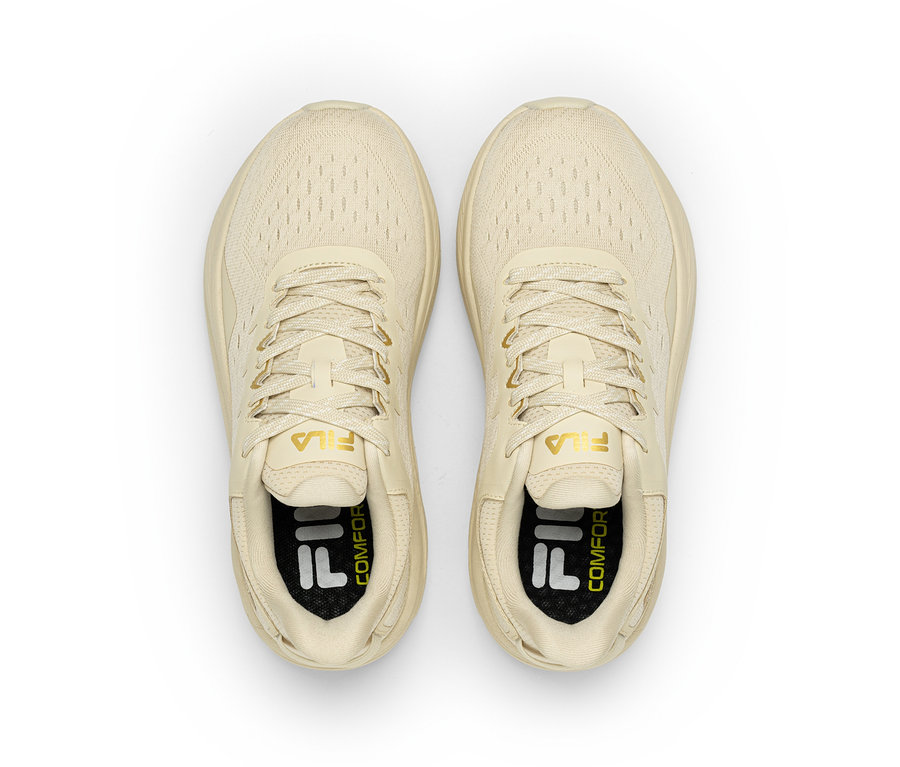Une paire de baskets Fila couleur crème avec des lacets, vue de dessus. Le logo Fila est visible sur la languette et la semelle intérieure.