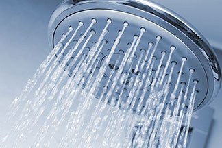 Un jet d'eau doux pour le bien-être : une pomme de douche ronde avec de l'eau qui jaillit.