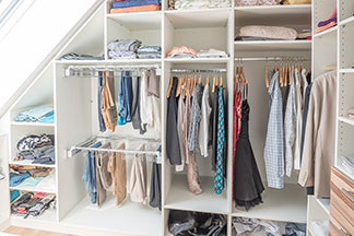 Tout d'un seul coup d'œil : une armoire de chambre de plain-pied avec de nombreuses étagères ouvertes et des compartiments où les vêtements sont suspendus et posés.