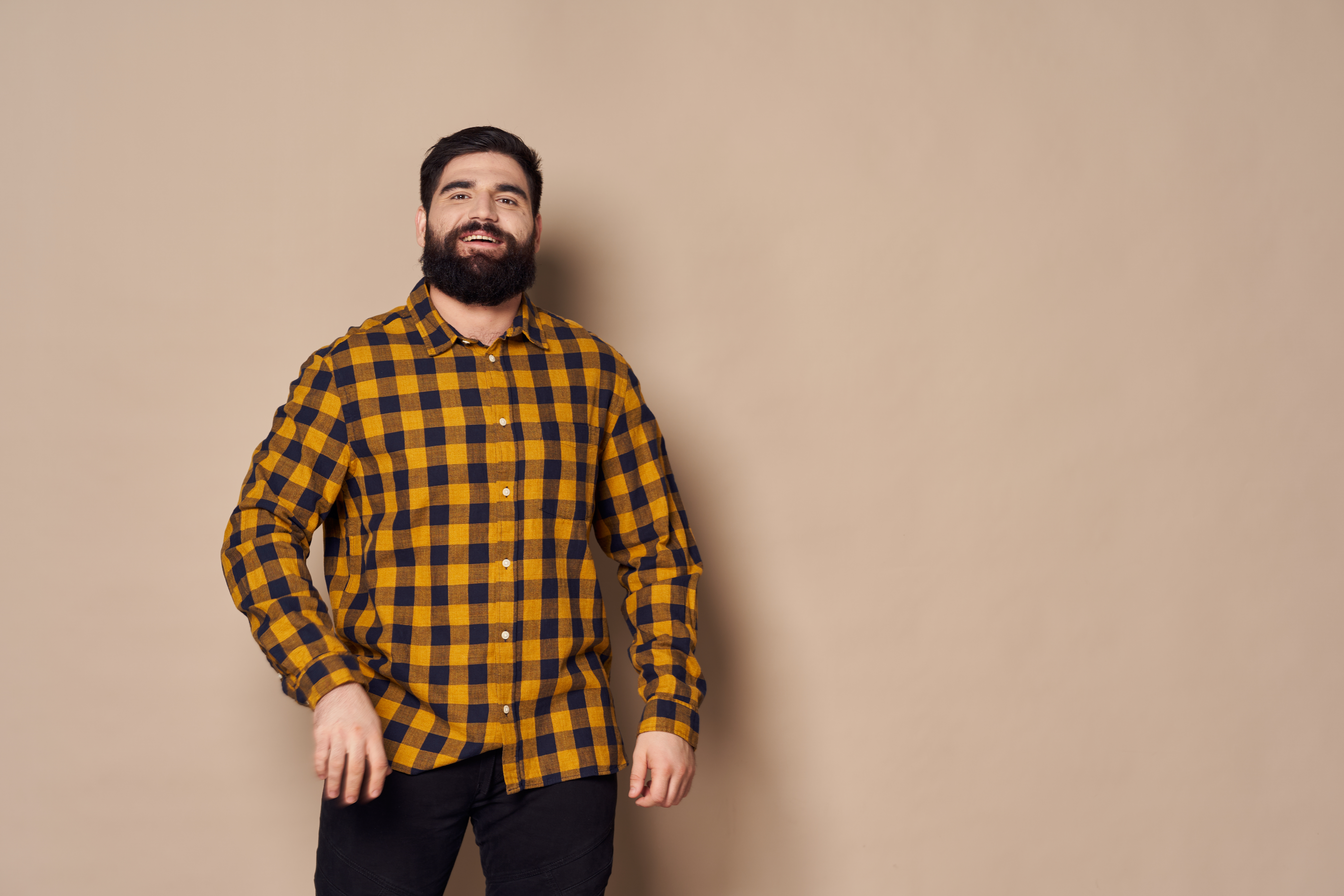 Homme portant une tenue de loisirs décontractée avec une chemise à carreaux.