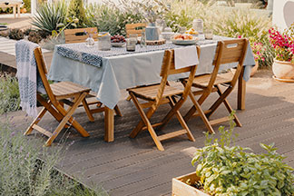 Le bon ensemble pour le jardin : une grande terrasse avec une grande table de jardin rectangulaire en bois et cinq chaises en bois.