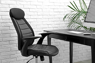 Être assis confortablement à son poste de travail : un grand fauteuil noir se trouve devant un bureau noir avec un écran et un clavier.