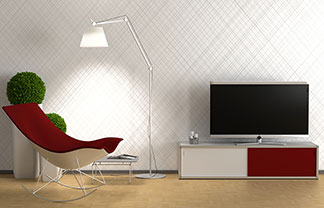 Dans un salon, il y a un lowboard rouge et blanc sur lequel se trouve une télévision ainsi qu'un fauteuil avec un couvercle rouge et un lampadaire.
