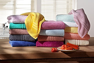 Un classique parmi les serviettes : une pile de serviettes en tissu éponge colorée dans une salle de bains.