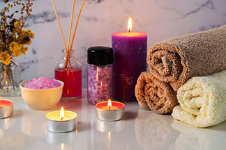 Des bougies pour une atmosphère de bien-être : un arrangement de deux bougies chauffe-plat différentes et une bougie violette créent une ambiance chaleureuse.