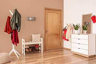 Un meuble à chaussures adapté à votre propre style : un grand couloir d'entrée avec un plancher en bois clair, un meuble à chaussures blanc, un portemanteau blanc et une commode blanche.