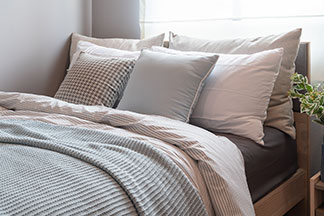 Grand choix d'oreillers : un lit avec de nombreux oreillers colorés de différentes tailles.