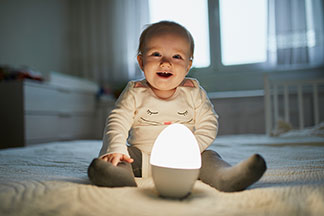 Dormir en toute sécurité : un bébé observe curieusement les environs depuis son berceau blanc.