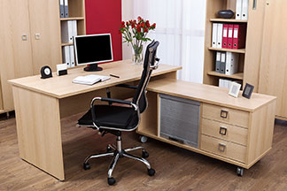 Poste de travail avec bureau en bois léger et diverses armoires de bureau.