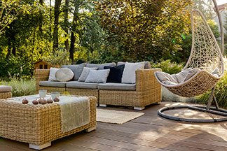 Un travail de haute qualité pour vos meubles de jardin : une terrasse en bois avec des meubles de salon et un fauteuil relax à mouvement libre.