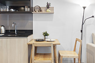 Veiller aux bonnes dimensions : dans une salle à manger, il y a une table carrée en bois avec deux chaises en bois sans accoudoirs.