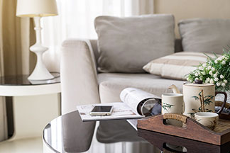 Multifonction : une table basse ronde avec un plateau à thé, un magazine ouvert et un smartphone.