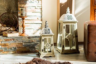 Tendance nostalgique : de grandes lanternes décoratives en verre d'aspect vintage se trouvent à côté d'une cheminée dans le salon.
