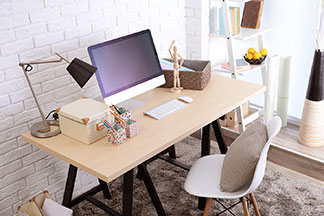 Lumière de travail : un bureau en bois sur lequel sont placés une lampe métallique grise ainsi qu'un ordinateur portable et du matériel de travail se trouve devant une fenêtre lumineuse.