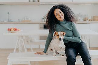 Le banc comme point central de la cuisine : une jeune femme est assise avec son chien sur un banc blanc dans la cuisine.
